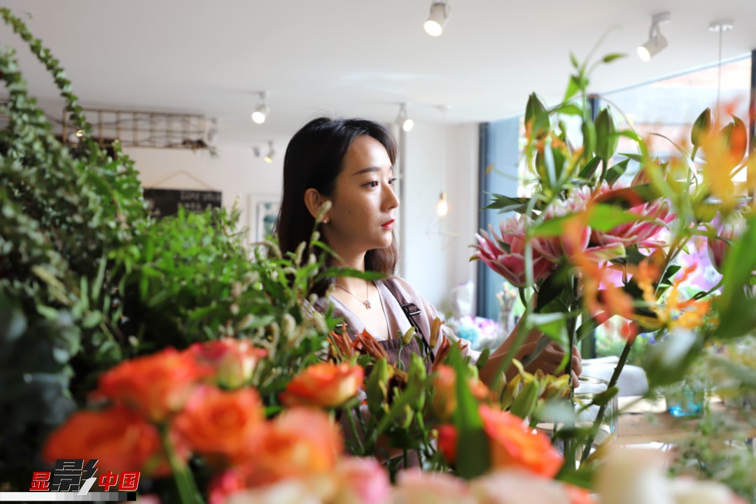 每天和花打交道是一個幸福的職業(yè)，但同時也充滿壓力和挑戰(zhàn)，“花在呈現(xiàn)給客人的那一瞬間是美好的，但前面的每一個步驟都是很辛苦的。”王黎媛說，花藝是最原始的手工藝產(chǎn)品，沒有辦法機(jī)械化、流程化和規(guī)模化，必須要用雙手一點(diǎn)點(diǎn)地賦予其生命和美感。圖為王黎媛在挑選制作花束的鮮花。新華網(wǎng) 周亞平/攝 念新洪/文
